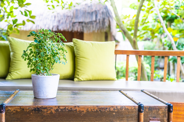 Tisch und Sofa mit grünen Kissen auf Balkon